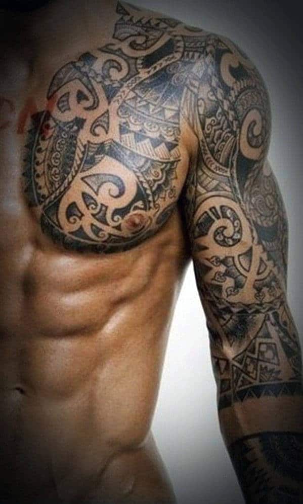 Close-up of a muscular man's chest and arm with intricate tribal tattoos