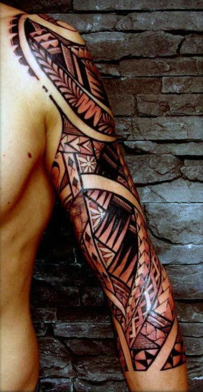 Person with a detailed, black and red tribal sleeve tattoo on their arm