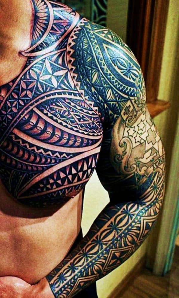 Man with intricate tribal tattoos covering his shoulder, chest, and arm