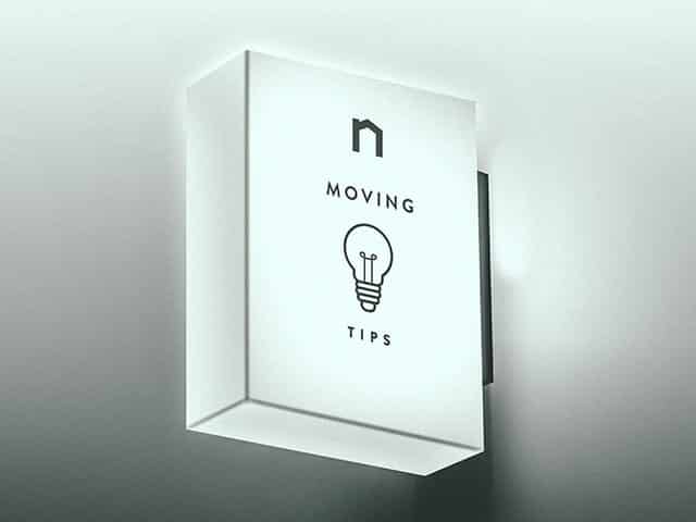 Square lamp with Next Moving logo and best moving tips and tricks, moving hacks text on it shines white light.