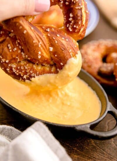 Dipping a soft pretzel into cheese sauce.