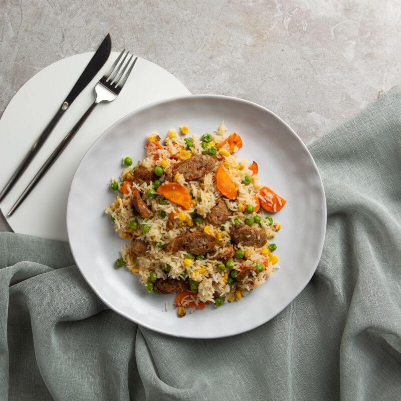 Our take on the classic Fried Rice served on a white ceramic plate on a marble bench top with a teal coloured cloth underneath.