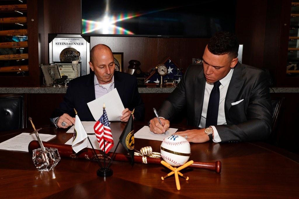 General manager Brian Cashman of the New York Yankees and Aaron Judge finalizing Judges nine-year contract.