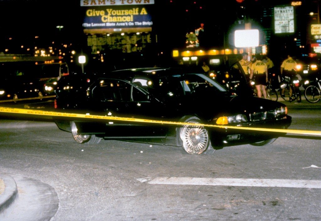 Black car in which rapper Tupac Shakur was fatally shot by unknown driveby assassins as he was riding w. friend Death Row records. pres. Marion Suge Knight, who survived shooting, behind police tape at crime scene