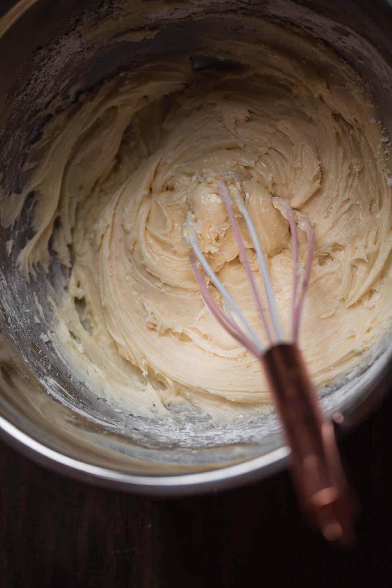 whisking the vegan frosting for the cake