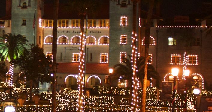 Lightner Museum and palm trees lit up with thousands of tiny white lights during the St. Augustine Nights of Lights event.