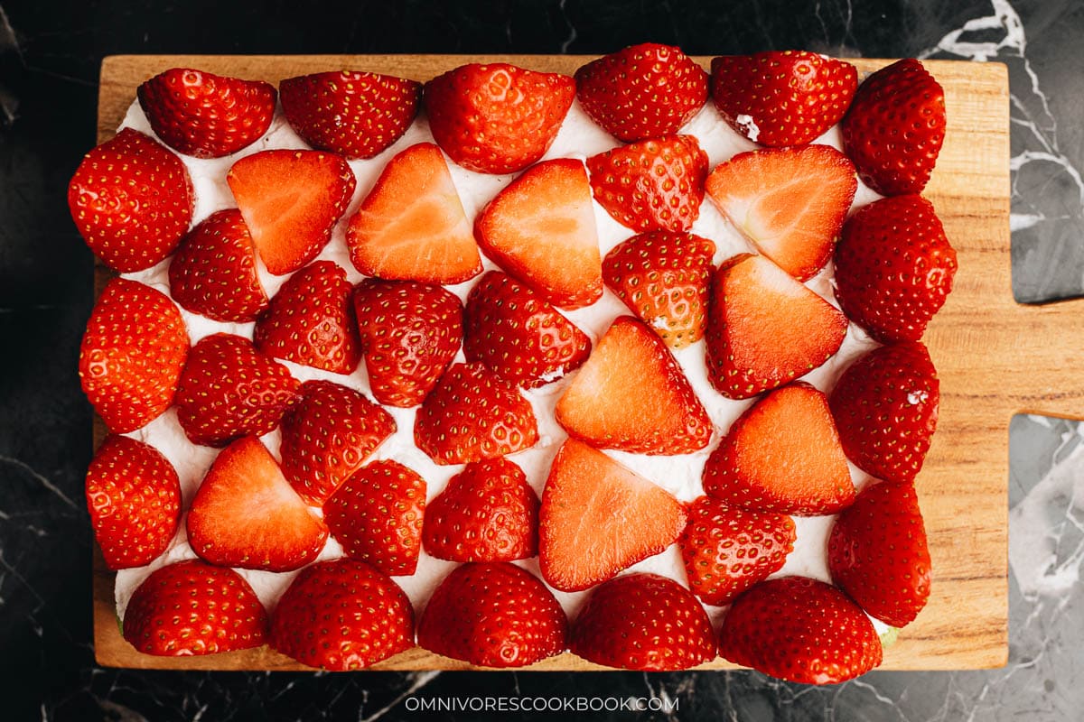 Decorating matcha cake by filling with strawberries