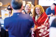 Chancellor Jennifer Mnookin wears a blanket presented to her by members of the Ho Chunk Nation