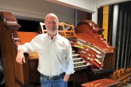 Paul Woelbing poses in front of a large organ