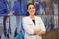 Olivia Rater smiling and wearing a white doctor's coat