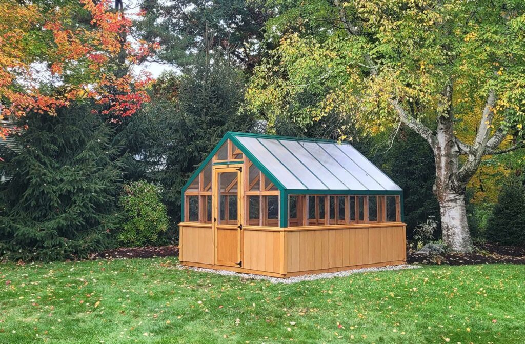 A tan greenhouse with green accents