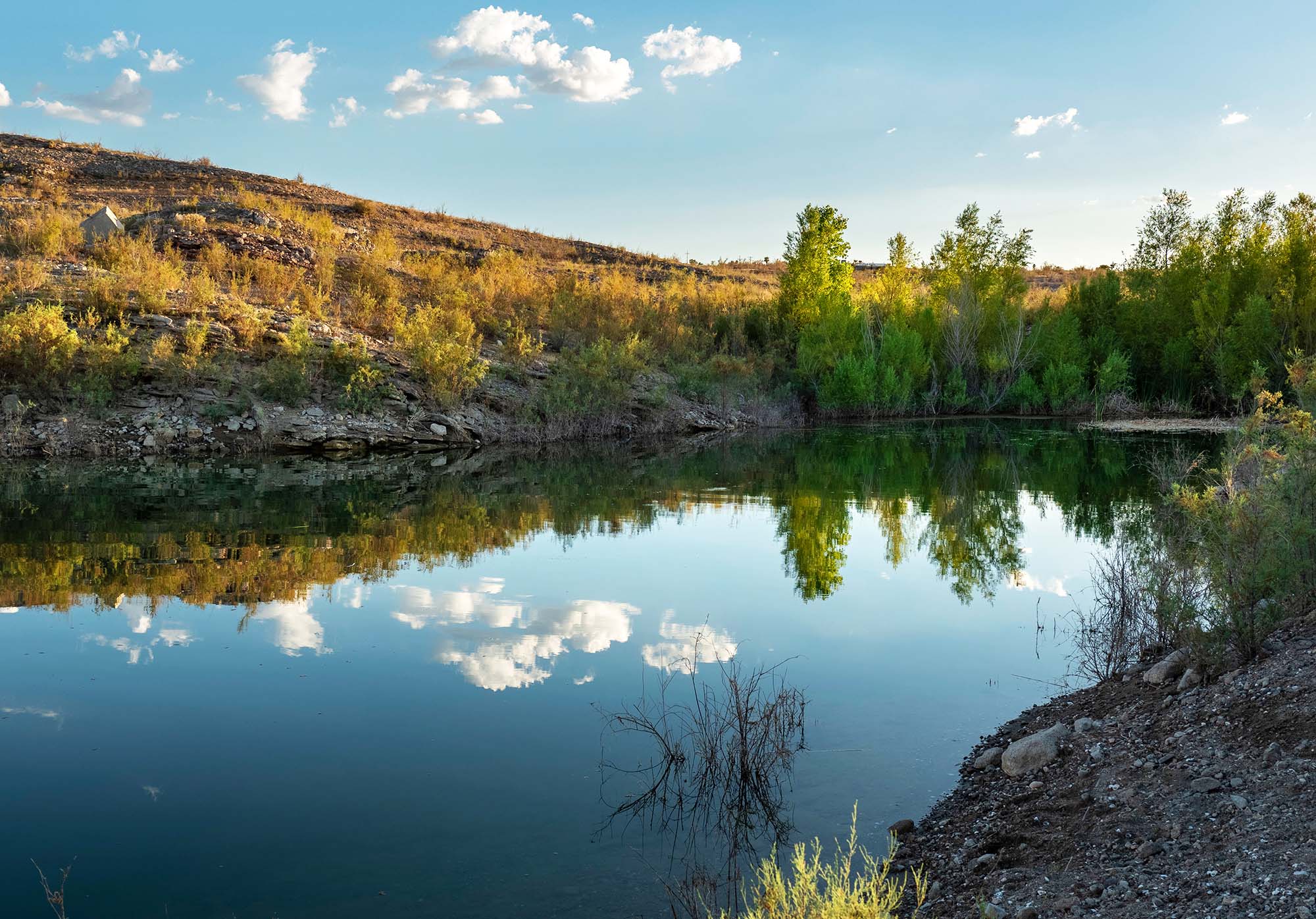 Cloudy blue sky reflected in a lake.