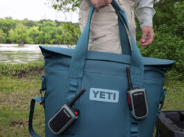 person holding a large blue Yeti cooler in front of a kayak launch