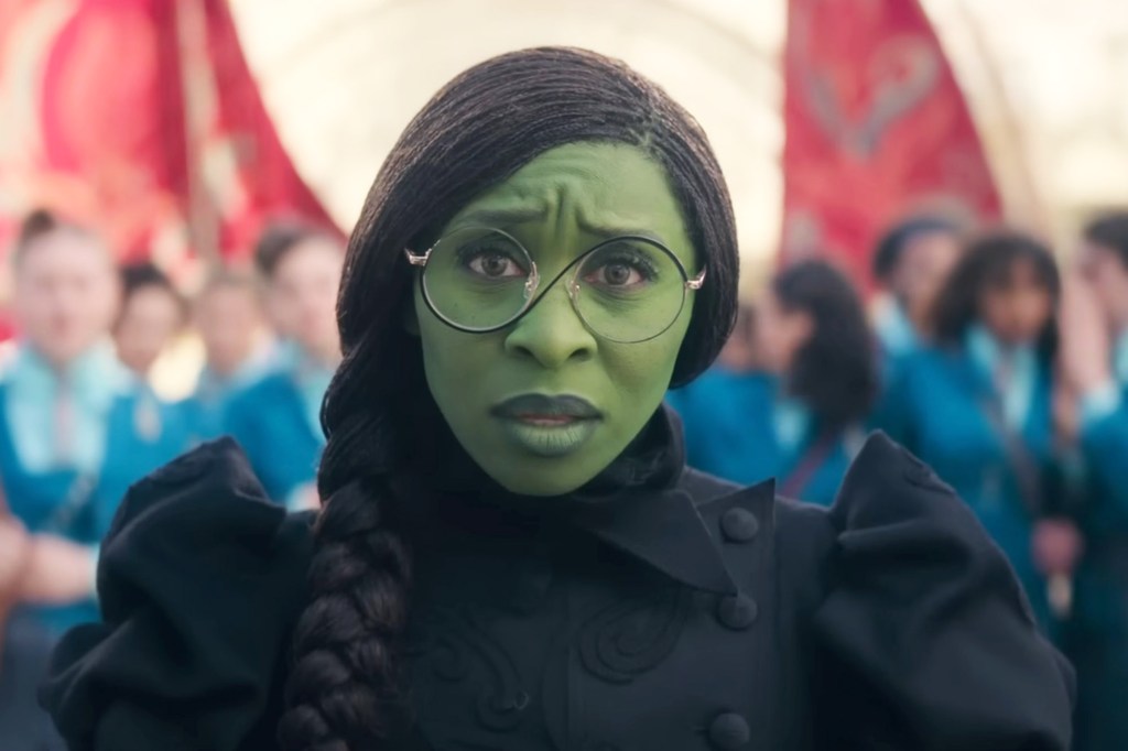 Cynthia Erivo in green make-up and a black coat.