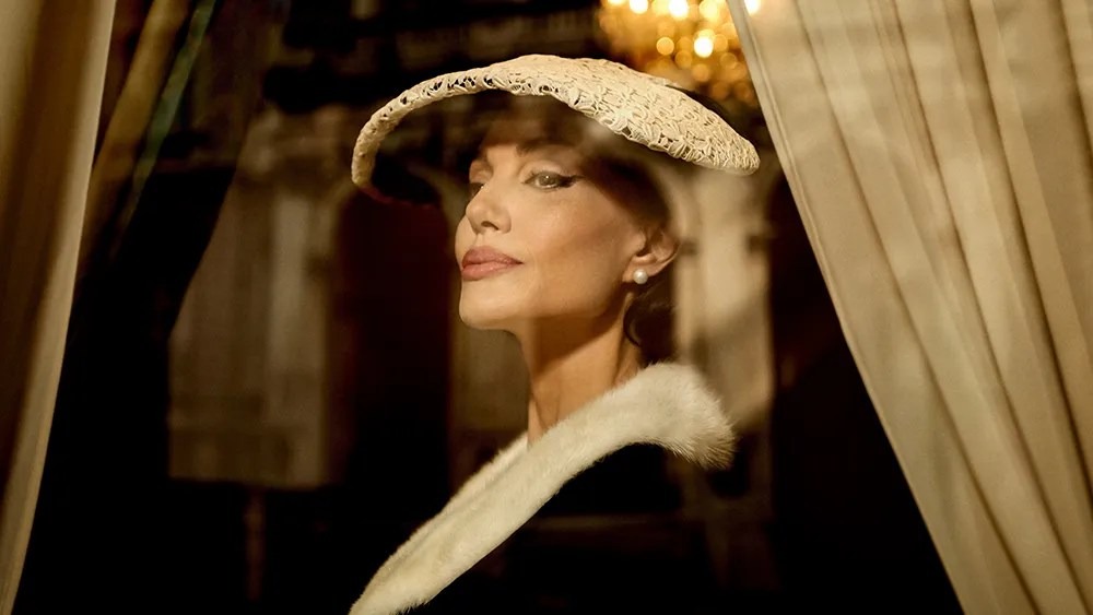 Angelina Jolie wears a lace hat and a coat with a fur trim..