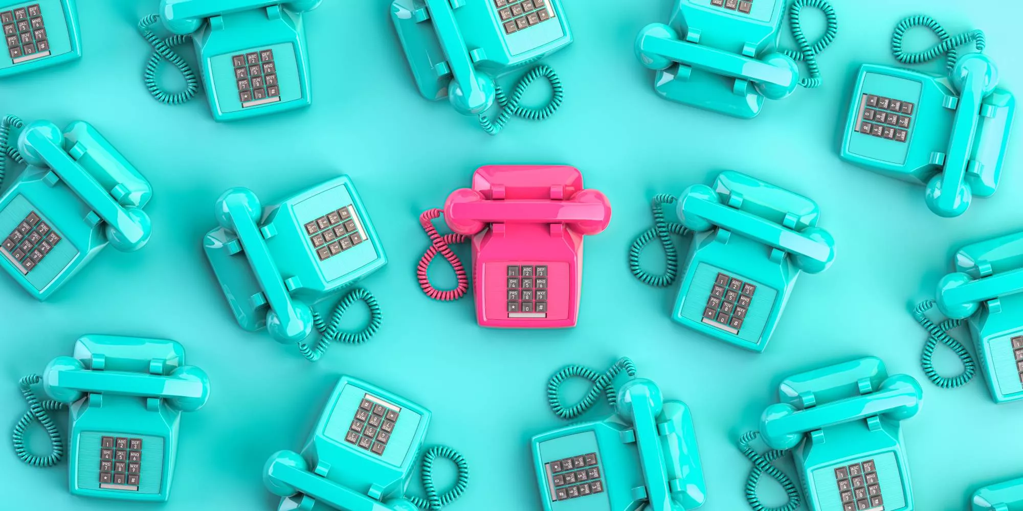 A pink phone in a sea of blue phones that will be used by a telephone answering service.