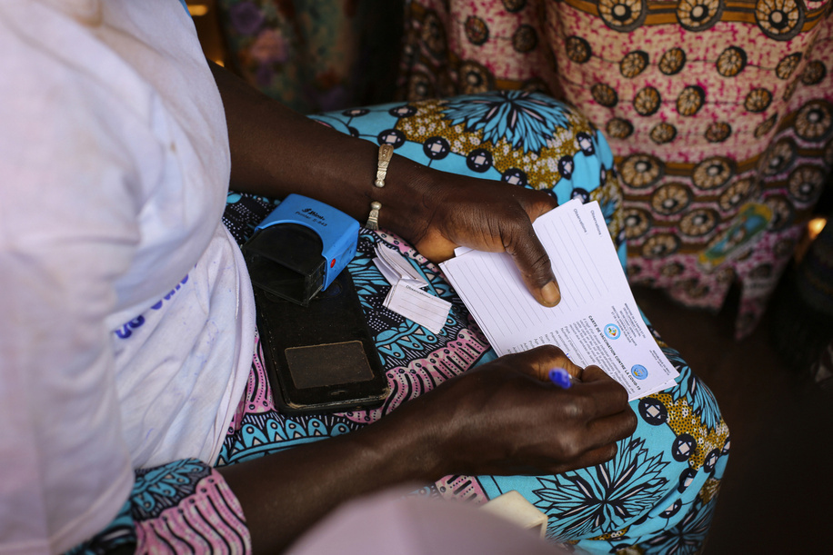 A vaccination officer fills out vaccination certificates during a COVID-19 vaccination campaign in Yirimadio Market, a community in the southeast of the Bamako, on 6 December 2022.  The COVID-19 Vaccination and Awareness-Raising Caravan team is made up of vaccinators and ambassadors who call on residents and market users to get vaccinated. As part of the first edition of Health and Welfare Month in Mali, the Caravan traveled through Bamako district's communes for 12 days. Partners vaccinated 1 million people during the campaign using a strategy of having vaccination teams go and meet people in their neighborhoods. The Caravan is a project implemented with funding from GAVI, the Vaccine Alliance.  About COVID-19 vaccination in Mali  Mali exceeded 10% primary series coverage in October 2022. Mali has developed a strong National Deployment and Vaccination Plan (NDVP) for COVID-19 vaccines, having revised it in March 2022 to adjust the strategy according to lessons learned during the first year of COVID-19 vaccination and to respond to challenges faced.  About the https://www.who.int/emergencies/diseases/novel-coronavirus-2019/covid-19-vaccines/covid-19-vaccine-delivery-partnership In January 2022, WHO, UNICEF and Gavi established the COVID-19 Vaccine Delivery Partnership (CoVDP) to intensify support to COVID-19 vaccine delivery. Working with governments and essential partners, CoVDP provided urgent operational support to the 34 countries that were at or below 10% full vaccination coverage in January 2022 on their pathways toward achieving national and global coverage targets. The greatest benefits of this approach were increases in full vaccination and booster coverage for in both general and high-priority populations – older adults, healthcare workers, and persons with co-morbidities, including immunocompromised persons. - Photo produced in collaboration with UNICEF