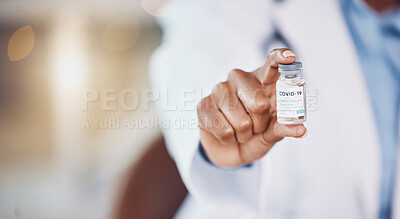 Closeup hand of african american woman doctor holding a bottle of the corona virus vaccine while standing in her hospital office. Be safe during the pandemic outbreak. Stop the spread of covid 19