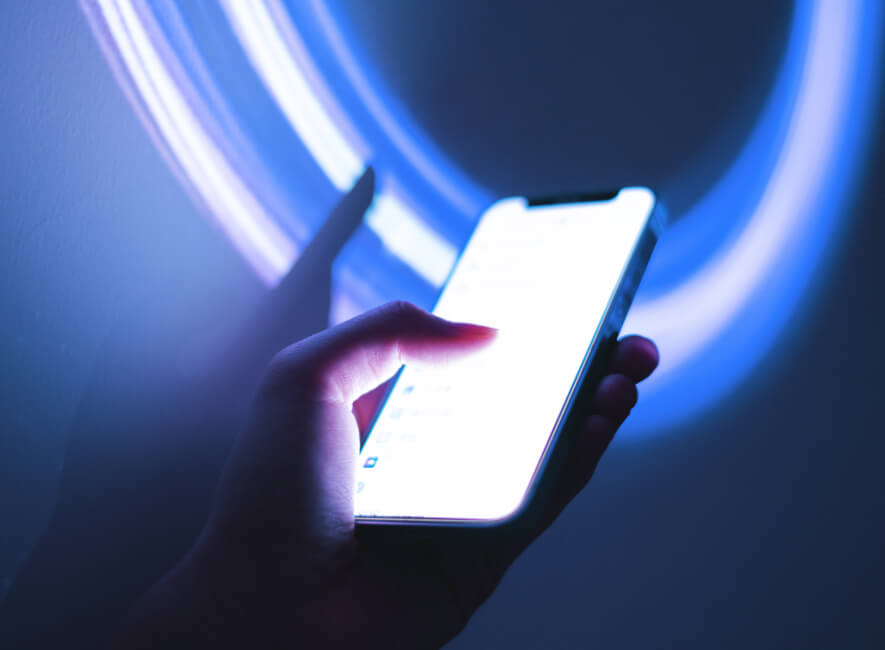 Abstract lights and a hand holding a cell phone