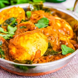 Kerala egg roast served in a silver serving dish topped with cilantro.