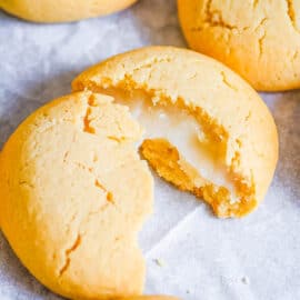 Mochi cookies stuffed with mochi filling, cracked open on a baking sheet.