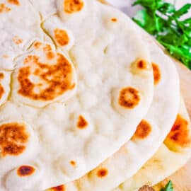 Yeast free vegan flatbread stacked on a cutting board.