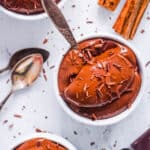 Healthy chocolate almond milk pudding served in white bowls topped with chocolate shavings.