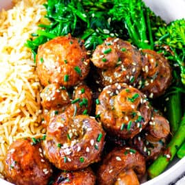 Miso mushrooms tossed with garlic miso butter, served in a white bowl with brown rice and fresh greens on the side.