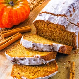 Vegan pumpkin banana bread, sliced on a wooden cutting board.