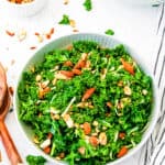 Copycat Chick-Fil-A kale salad served in a white salad bowl, garnished with almonds, top view.