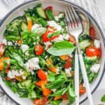 tomato avocado cucumber salad in a white bowl