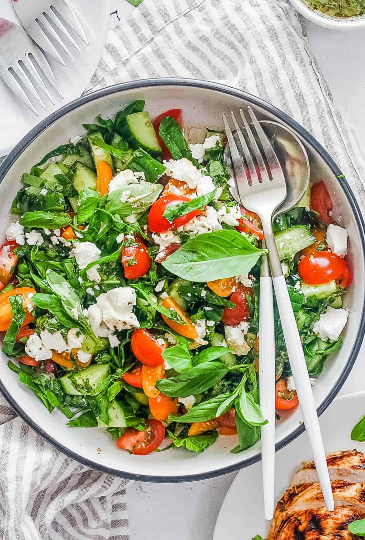 tomato avocado cucumber salad in a white bowl