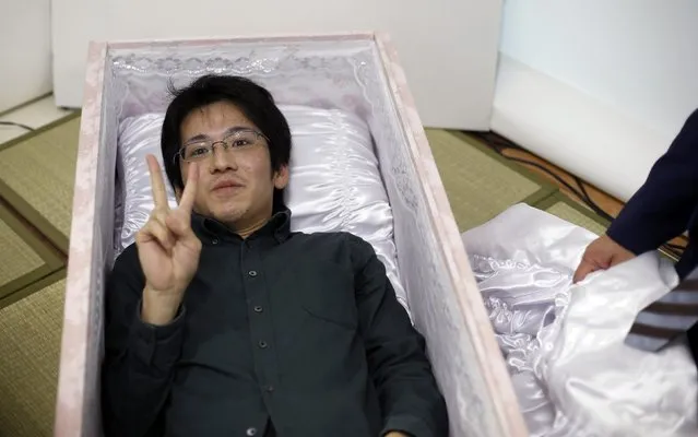 Noriaki Iwashima gestures as he lies in a coffin to try it out during an end-of-life seminar held by Japan's largest retailer Aeon Co in Tokyo October 24, 2014. (Photo by Toru Hanai/Reuters)