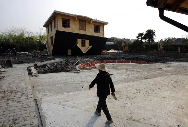 A female labourer walks next to an upside-down house under construction at Fengjing Ancient Town, Jinshan District, south of Shanghai, March 17, 2014. (Photo by Carlos Barria/Reuters)