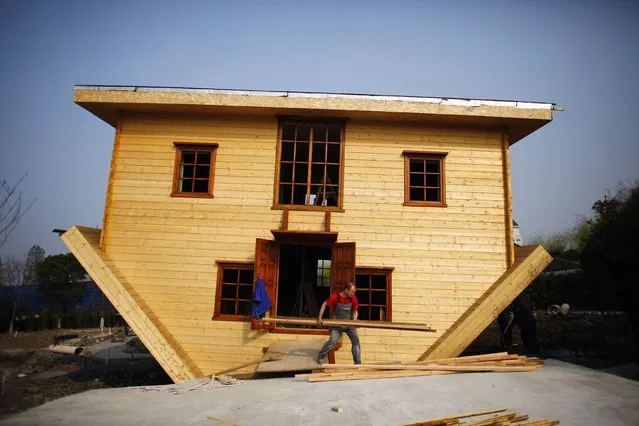 A labourer works at an upside-down house under construction at Fengjing Ancient Town, Jinshan District, south of Shanghai, March 17, 2014. (Photo by Carlos Barria/Reuters)