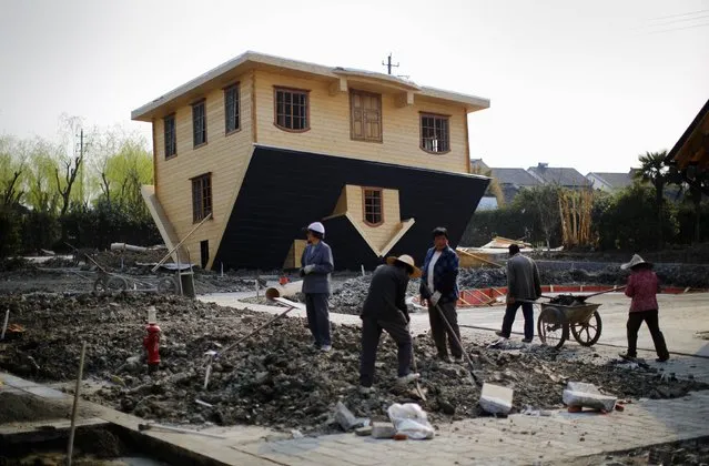 Labourers work at an upside-down house under construction at Fengjing Ancient Town, Jinshan District, south of Shanghai, March 17, 2014. (Photo by Carlos Barria/Reuters)