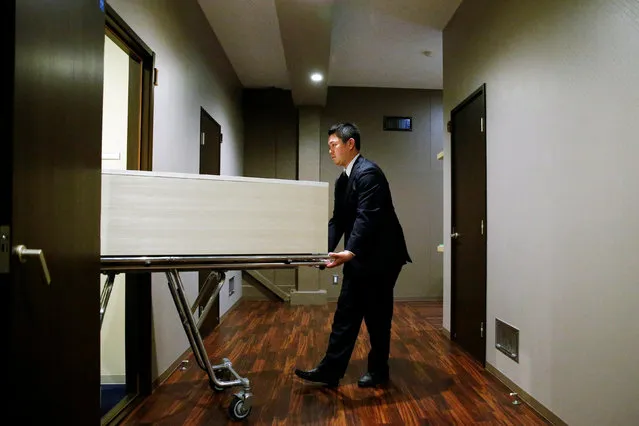 A staff member removes a coffin from a room of the “Corpse Hotel” in Kawasaki, Japan, April 20, 2016. (Photo by Thomas Peter/Reuters)