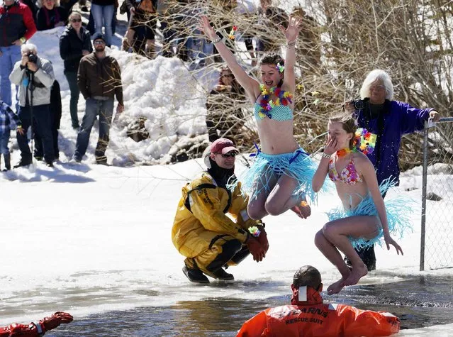 Two women jump into a frozen pond as they compete in the Polar Plunge at Frozen Dead Guy Days in Nederland, Colorado March 14, 2015. (Photo by Rick Wilking/Reuters)