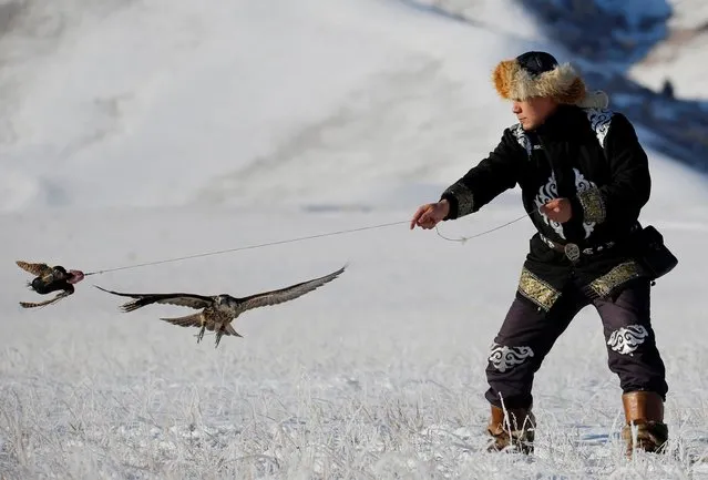 A hunter performs with his tamed hawk during a traditional hunting contest outside the village of Kaynar in Almaty region, Kazakhstan on December 8, 2019. (Photo by Pavel Mikheyev/Reuters)