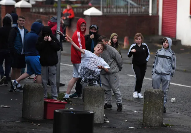 Nationalist youths throw bottles at police officers after the annual Orange march on July 12, 2016 in Belfast, Northern Ireland. The controversial Ardoyne interface is a flash point between the Catholic and Protestant communities with trouble flaring in the area frequently during the so called marching season. (Photo by Charles McQuillan/Getty Images)