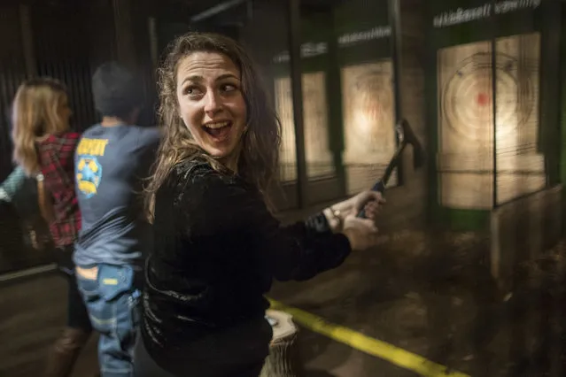 In this Saturday, March 3, 2018, photo, a contestant gets ready to throw a hatchet at a wooden bull's-eye at the Kick Axe Throwing venue in the Brooklyn borough of New York. (Photo by Mary Altaffer/AP Photo)