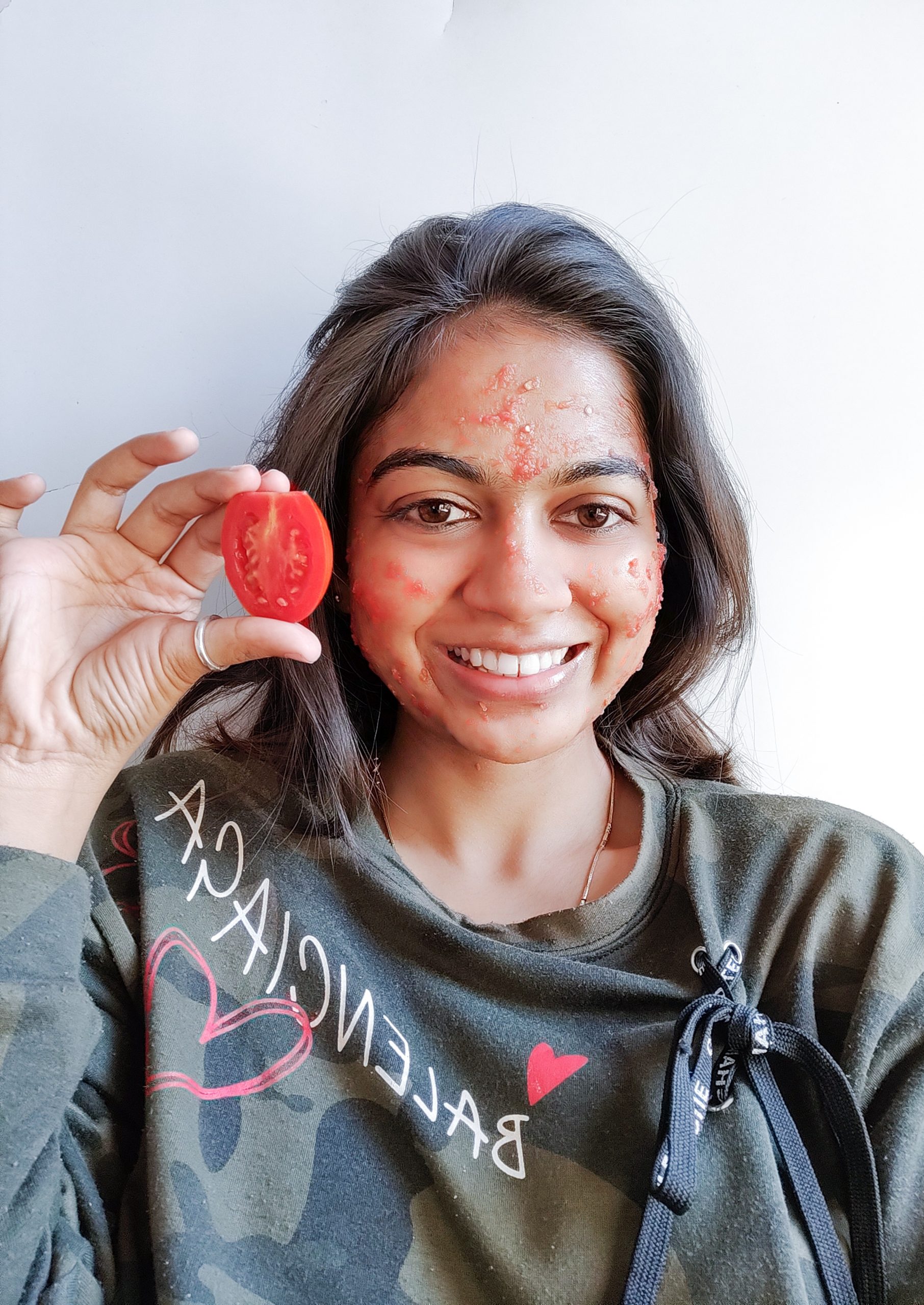 A girl applying tomato face mask