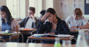 Shot of a student struggling with schoolwork in a classroom