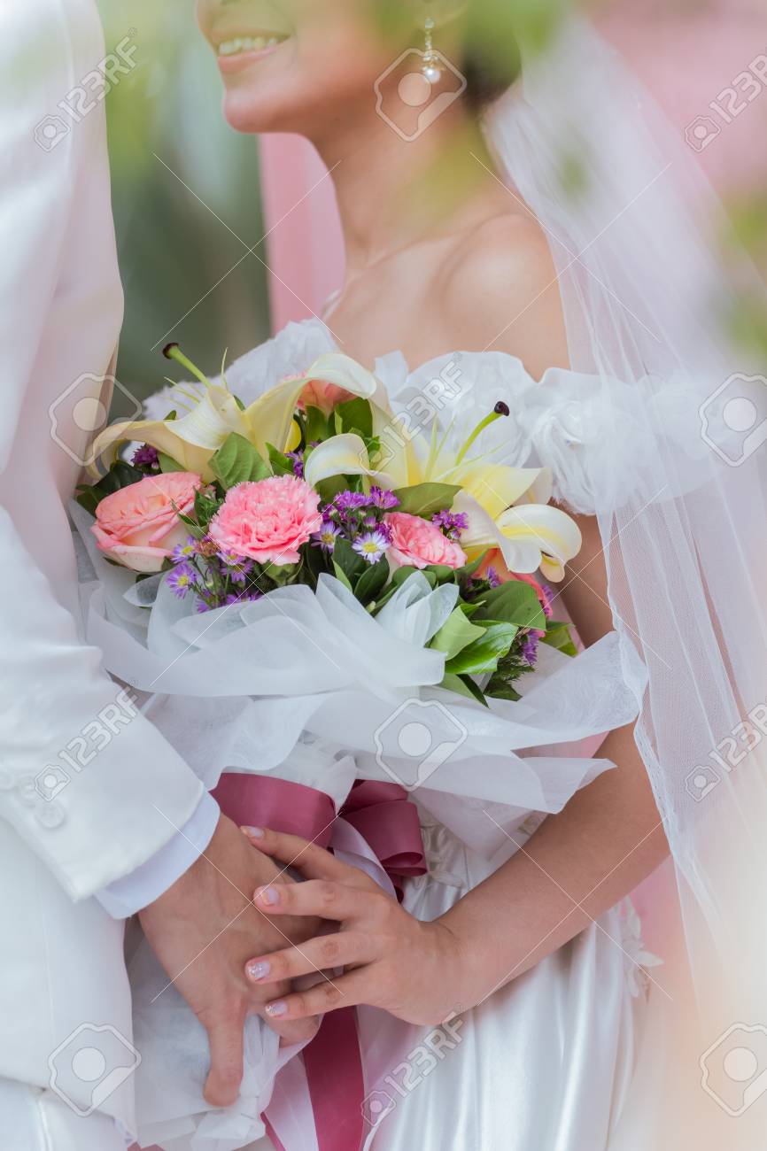 Couple Holding A Bouquet Of Flowers With A Happy Wedding Day Is ...