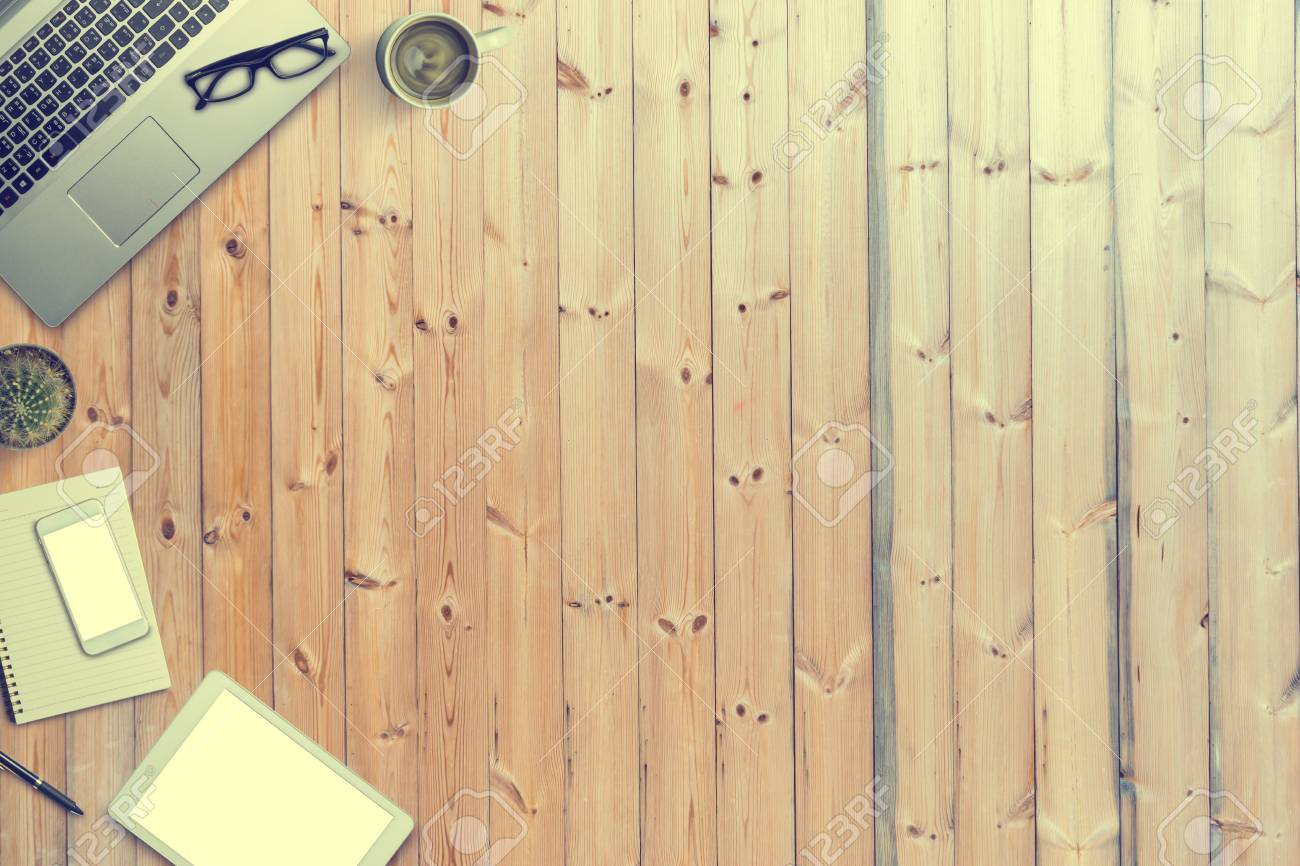 Top View Of A Laptop On Old Wooden Table  Supplies,  Gadgets, Coffee, Smartphone, Tablet, Cactus, Notebook, Pen And Glasses.  Copy Space. Vintage Tone Stock Photo, Picture And Royalty Free Image. Image