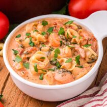 Creamy Tortellini Soup on a wooden table.