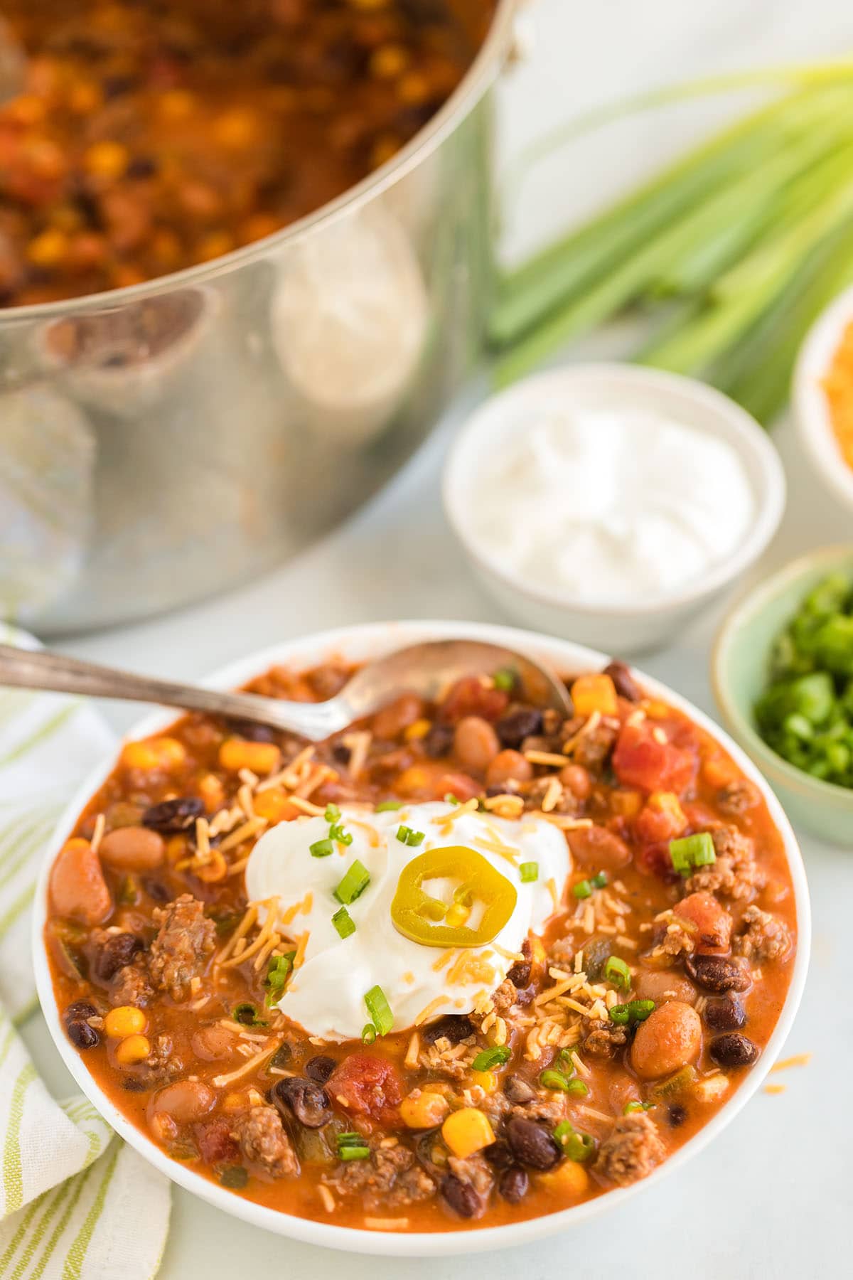 a bowl of taco soup topped with sour cream and jalapeno slice.