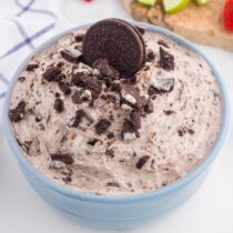 Oreo Dip topped with crushed Oreo cookies in a blue bowl.