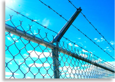 Chain link fence with barb wire arm and barbed wire.