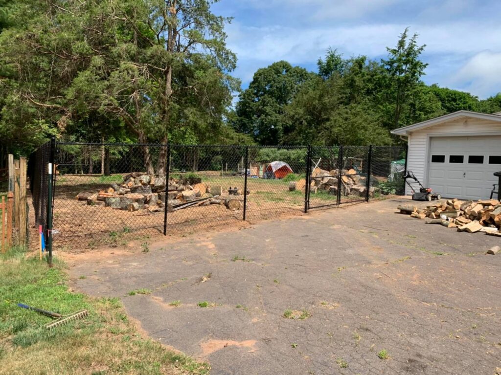 Six foot tall residential chain link fence in black with a double drive gate.